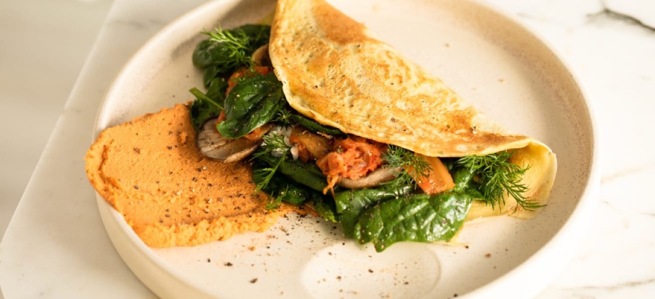Folded omelette on a plate with herbs
